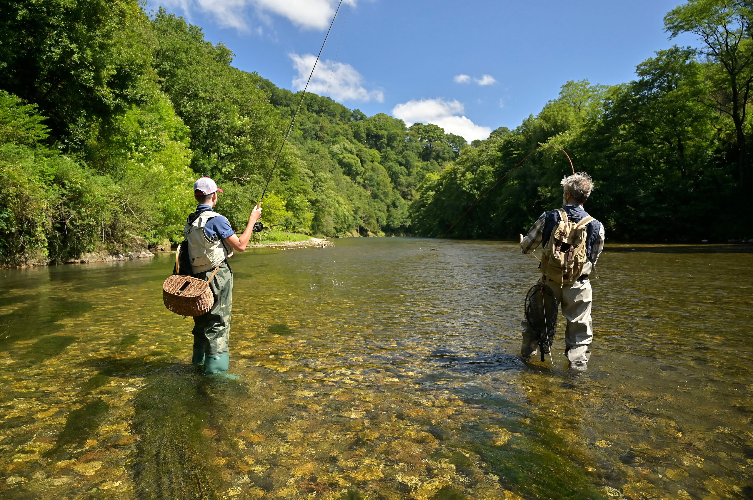 A Father And His Son Fly Fishing In Summer